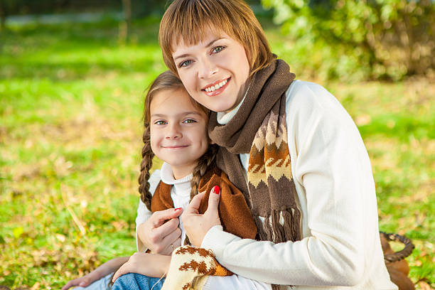 Felice madre con figlia piccola in autunno parco - foto stock