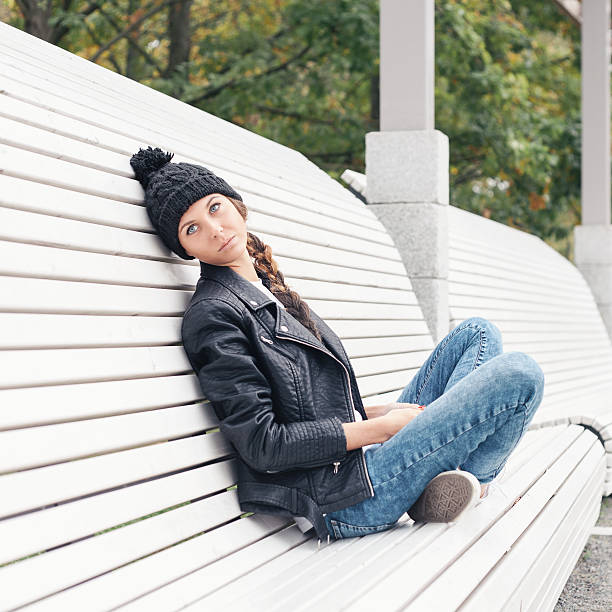 istock Young woman sitting on a park bench 523721463