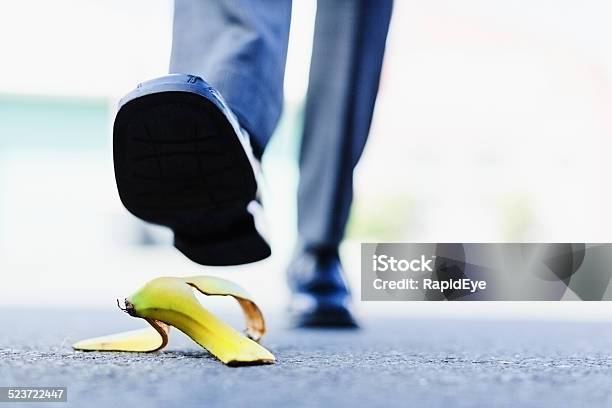 Male Foot In Dress Shoe Approaches Banana Skin Accident Alert Stock Photo - Download Image Now