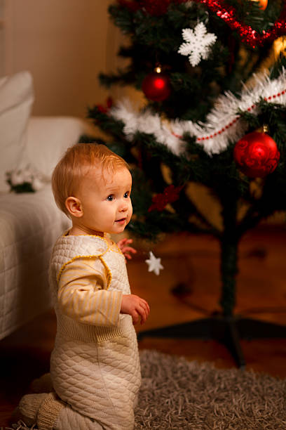 istock Lovely baby near Christmas tree looking on side 523722793