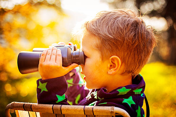 istock Little boy exploring with binoculars outdoors 523722837