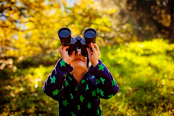 istock Little boy exploring with binoculars outdoors 523722891