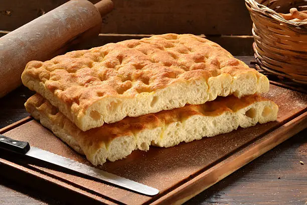 Foccacia bread on rustic wood table and background.