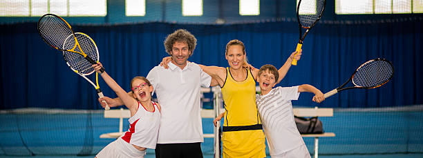 portrait d'une famille de jouer à l'intérieur, de tennis - indoor tennis photos et images de collection