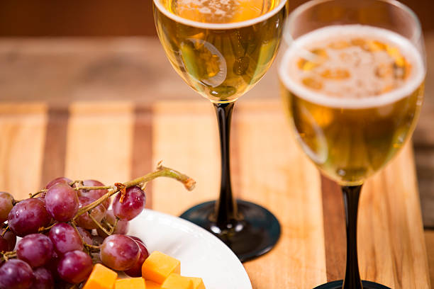 White wine tasting event. Cheese and red grapes. Wooden table.