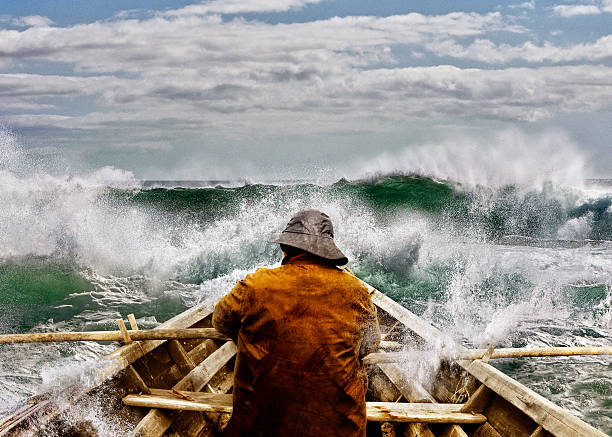 Old man and the Sea in a Skiff Old man and the sea, in a rowboat or skiff paddling and fighting the waves of the ocean. sea storm stock pictures, royalty-free photos & images