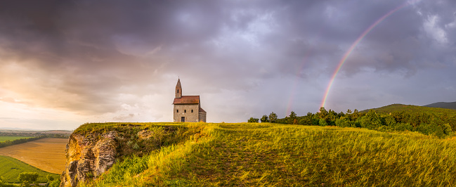 Old Roman Catholic Church of St. Michael the Archangel with Rainbow on the Hill at Sunset in Drazovce, Slovakia