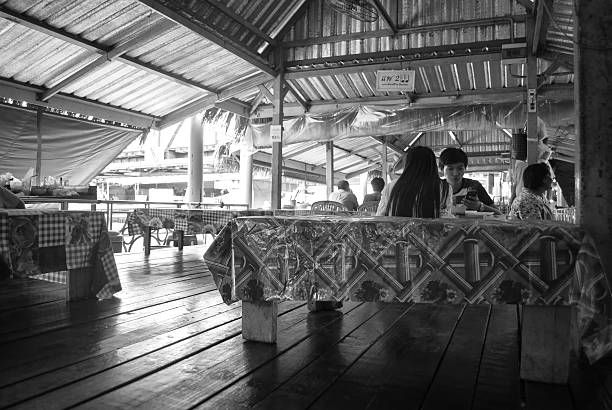 Bangkok, Thailand - August 9, 2014: black and white of people eating at the floating market of Bangkok during the day