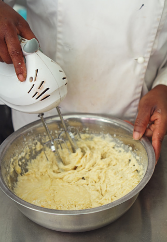 Close up of pastry chef hand mixer beating cupcake batter