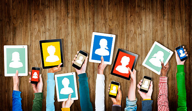 istock Group of Hands Holding Digital Devices with Avatar Symbols 523748621