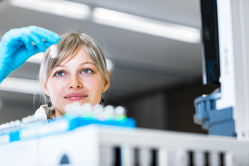 Portrait of a female researcher carrying out research in a high-tech chemistry lab (color toned image; shallow DOF)
