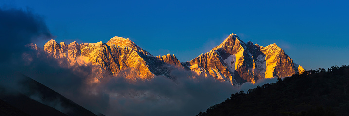 The iconic summit pyramid of Mt. Everest (8848m), sawtooth ridge of Nuptse (7861m) and snow capped spire of Lhotse (8501m) illuminated by golden sunset light above the Khumbu valley deep in the Himalaya mountain wilderness of the Sagarmatha National Park, Nepal, a UNESCO World Heritage Site. ProPhoto RGB profile for maximum color fidelity and gamut.