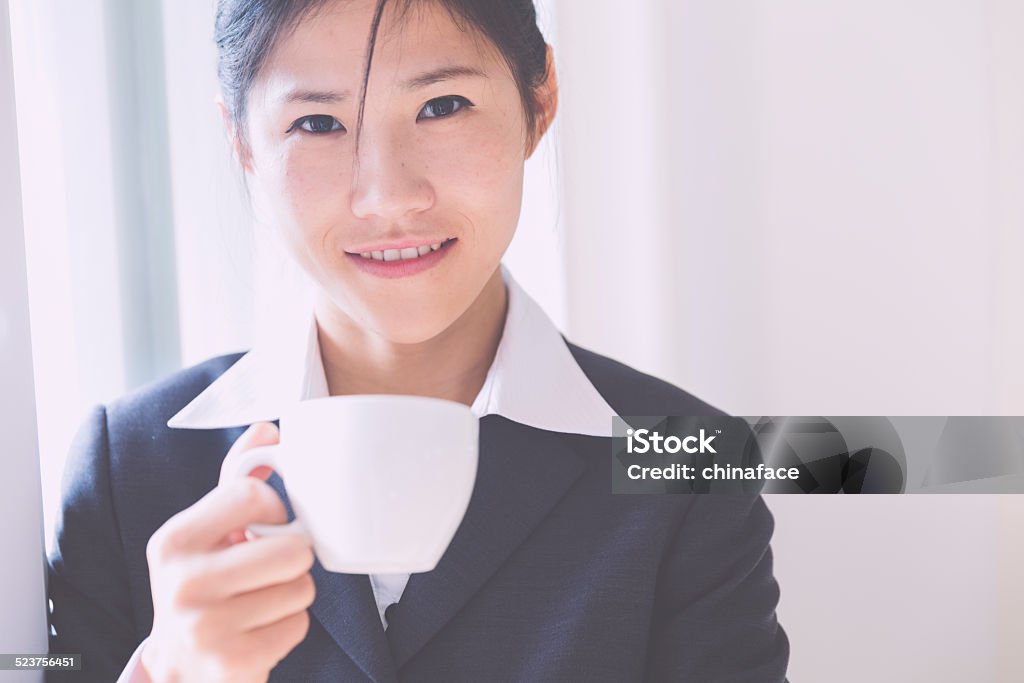 Beginning of the business day,asian businesswoman asian businesswoman holding a cup of coffee in office building, china. 20-24 Years Stock Photo