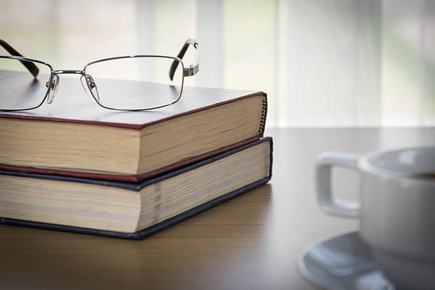 istock Book and Eyeglasses on a wood table 523764532