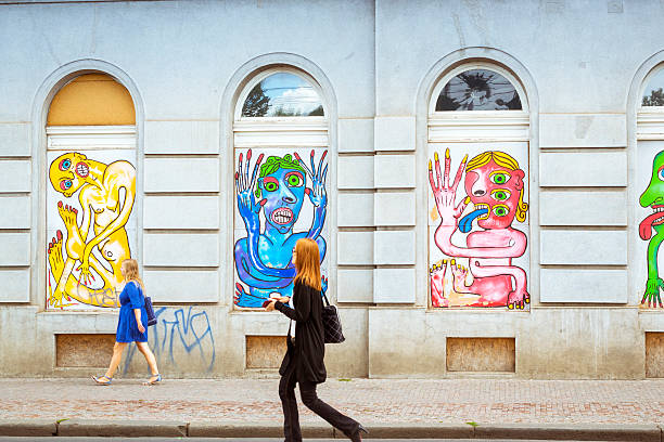 Street art - colorful images of freaks, monsters, aliens Prague, Czech Republic - August 25, 2015: Two girls are against the wall. Street art - colorful images of freaks, monsters, aliens in the window bays in the old town of Prague, Czech Republic prague art stock pictures, royalty-free photos & images
