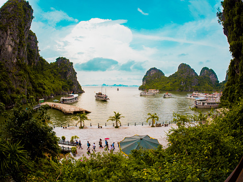Ha Long, Vietnam - September 20, 2014: View of the port in Ha Long Bay, Vietnam. Several boats and ferries can be seen in the background and people can be seen going around.