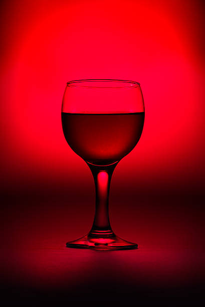 istock Glass of wine on red 523769536
