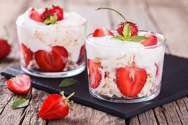 Eton Mess - Strawberries with whipped cream Eton Mess - Strawberries with whipped cream and meringue in a glass beaker. Classic British summer dessert.selective focus strawberry crush stock pictures, royalty-free photos & images