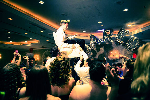 Let's Party! Bar Mitzvah celebration. Brother of the Bar Mitzvah boy is held up on a chair. It is traditional for the child and his family to be raised on chairs during the party. jodijacobson stock pictures, royalty-free photos & images