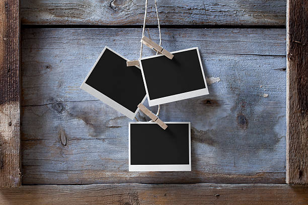 Blank photos hanging Blank photos hanging from a rope on a wooden background. three objects photos stock pictures, royalty-free photos & images