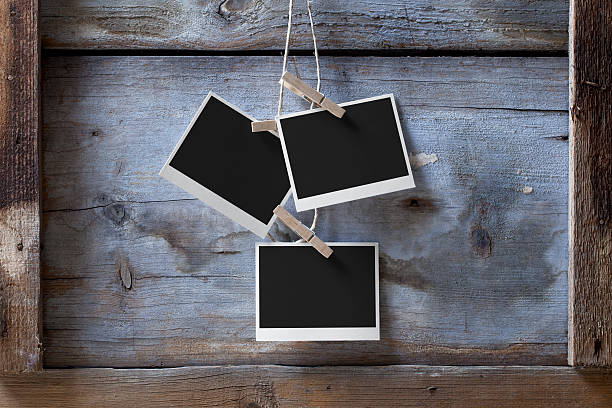 Blank photos hanging Blank photos hanging from a rope on a wooden background. clothespin wood stock pictures, royalty-free photos & images