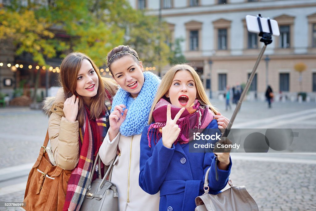 Young friends together making selfie Young friends together making selfie with a selfie stick and smart phone. 20-24 Years Stock Photo