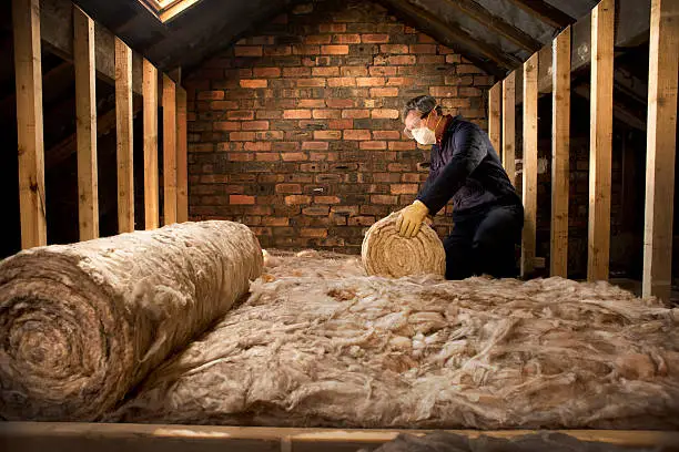 man puts insulation in his loft