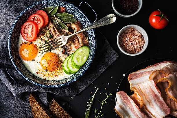 istock Breakfast set. Pan of fried eggs with bacon, fresh tomato 523819862