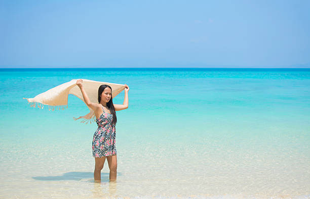 istock Woman holding sarong on paradise beach. 523821300