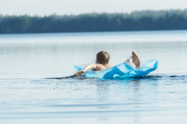 Nastolatki wiosłować z ramionami i pływających w basenie niebieski Lilo – zdjęcie