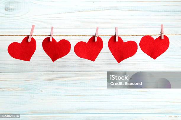 Love Hearts Hanging On Rope On A Blue Wooden Background Stock Photo - Download Image Now