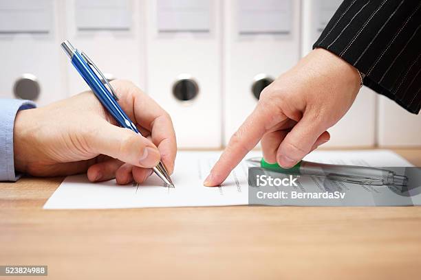 Business Woman Is Pointing Where To Sign On Document Stock Photo - Download Image Now