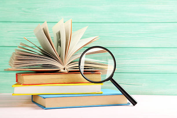 istock Magnifying glass on a pink wooden table 523826092