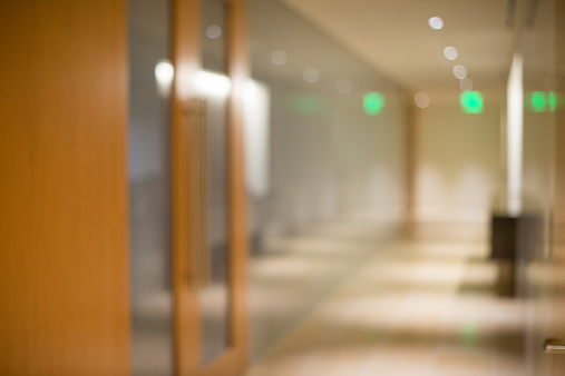 Defocused corporate office conference room and corridor with glass walls background.