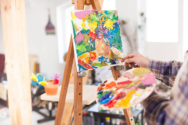 istock Painter's palette and new artwork on easel 523827018