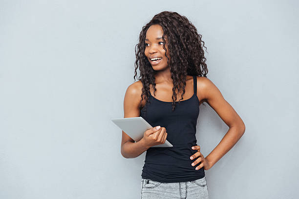 istock Cheerful afro american woman holding tablet computer 523827552
