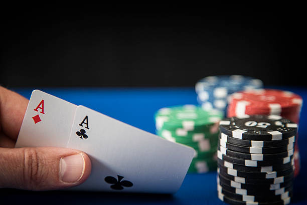 istock Two aces in hand and Gambling chips on casino blue 523827906