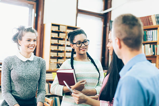 istock Group of classmates discussing homework at the library 523828782