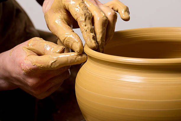 istock hands of a potter, creating an earthen jar 523829877