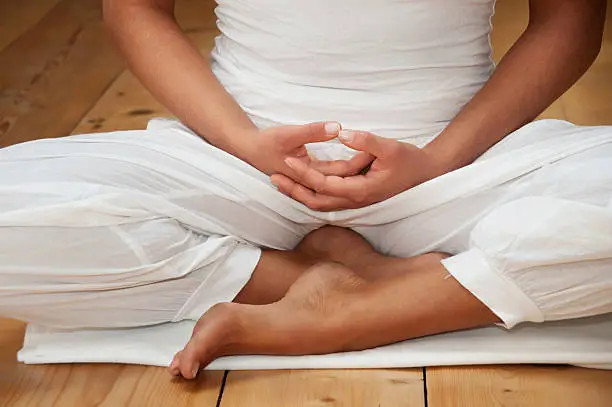 Meditator sitting with the hands on the lap.