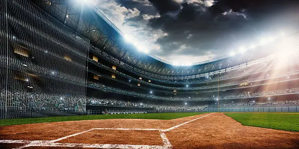 A wide angle of a outdoor baseball stadium full of spectators under a stormy night sky. The image has depth of field with the focus on the foreground part of the pitch. Stadium and all elements are made in 3D. 