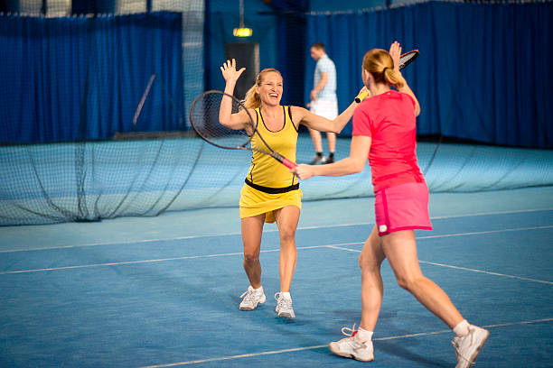 共同女性テニスプレーヤーギブ、ハイファイブ - tennis indoors women court ストックフォトと画像