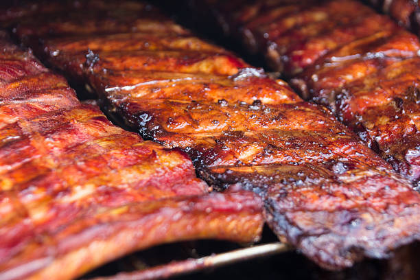 Spare ribs on grill - smoked pork ribs Grilled spare ribs macro - pork ribs bbq smoker stock pictures, royalty-free photos & images