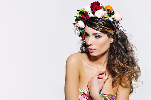 Beauty portrait of a gorgeous woman with gipsy hairstyle wearing handmade fairy flower crown