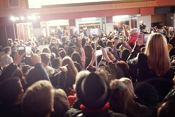 multitud y ventiladores en la alfombra roja estreno de película - estreno de película fotografías e imágenes de stock