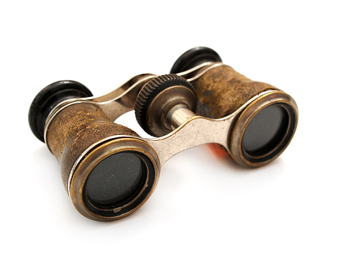 Antique brass binoculars at white background