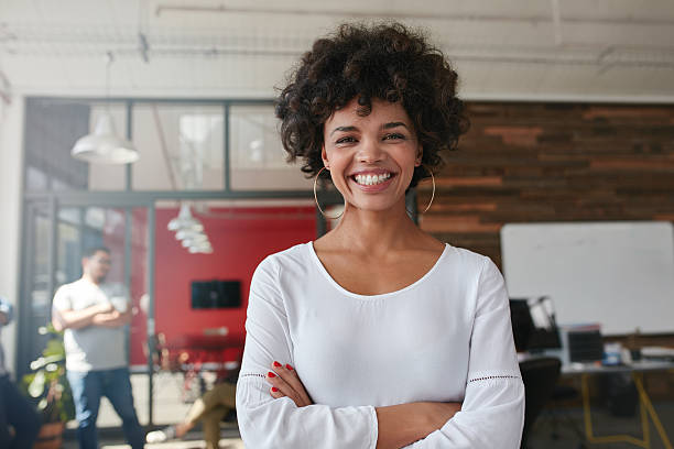 istock Smiling young woman standing in creative office 523859608