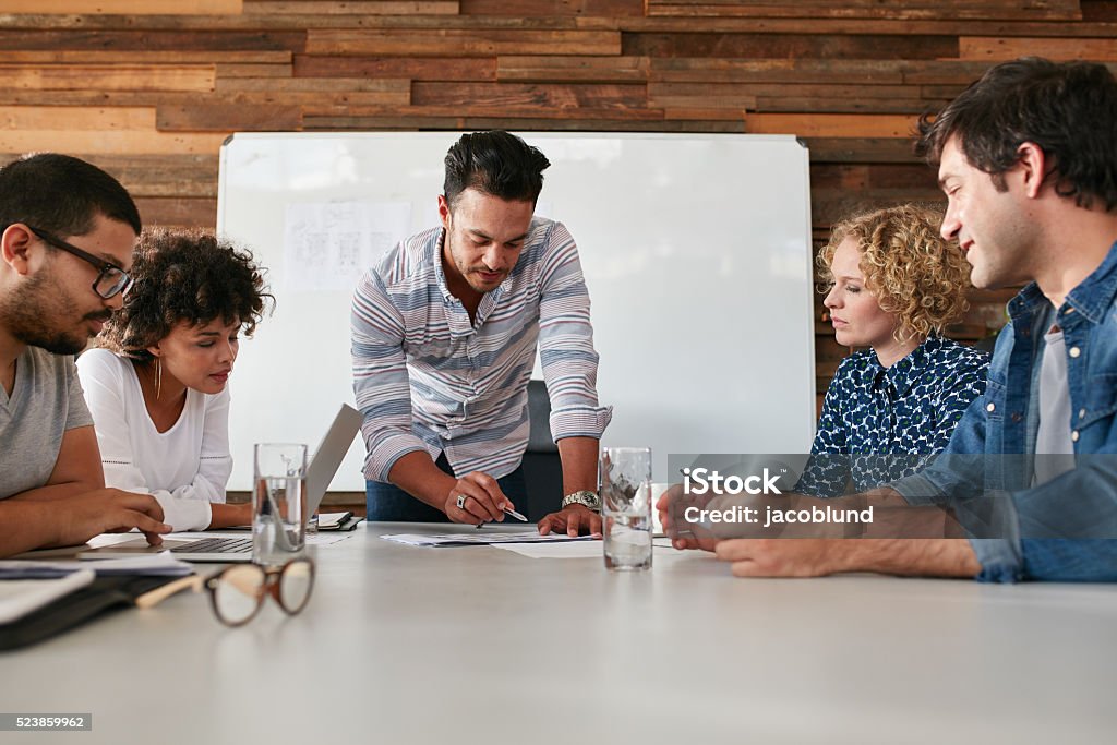 Creative team discussing new ideas on table Startup team working and planning in the meeting. Team of young professional discussing new creative ideas on table in boardroom. Travel Agency Stock Photo