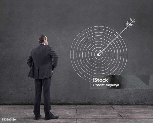 Businessman With Arrow Hits The Target Sketched On The Wall Stock Photo - Download Image Now