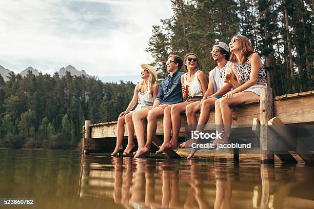 Eine Gruppe Von Freunden Sitzen Auf Anlegesteg Am See Stockfoto und mehr Bilder von Freundschaft